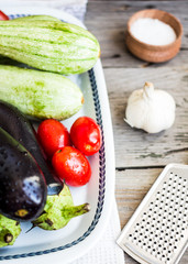 fresh vegetables for ratatouille on gray wooden table, rustic,cl