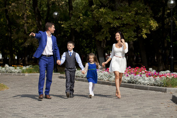 Fototapeta premium Szczęśliwa rodzina spacerując wzdłuż podmiejskiej ulicy
