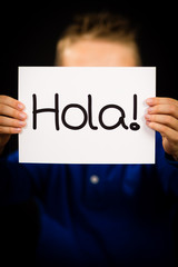 Child holding sign with Spanish word Hola - Hello © Mikkel Bigandt