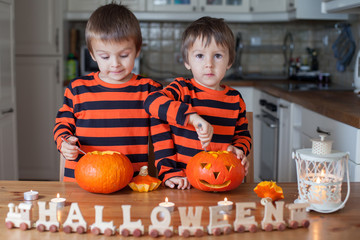 Fototapeta premium Two boys at home, preparing pumpkins for halloween