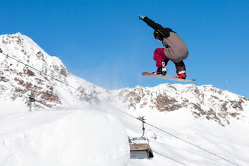 Naklejka na ściany i meble Snowboarder jumping in snow park