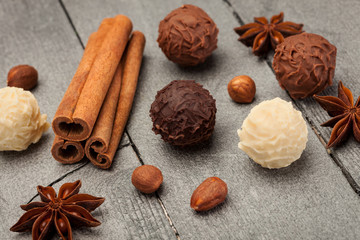 Chocolate truffles and spices over wooden table
