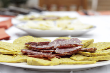 Salchichon slices, typical spanish saussage, beside artisan sausage made of meat, eggs and several spices