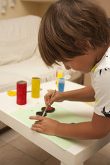 Niño pintando en casa con témperas de colores