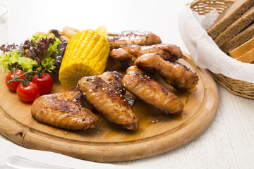 chicken wings are grilled on a wooden platter