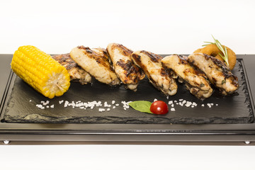 chicken wings are grilled on a wooden platter