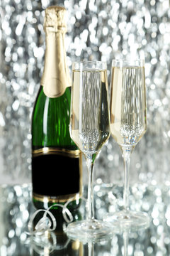 Glasses of champagne with bottle on a lights background