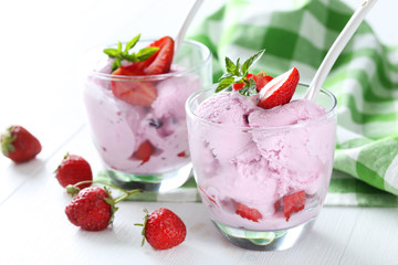 Ice cream in glasses with strawberries on white wooden backgroun