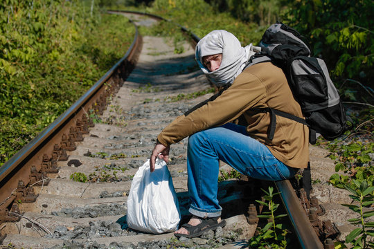 Man acting as a refugee on a railway
