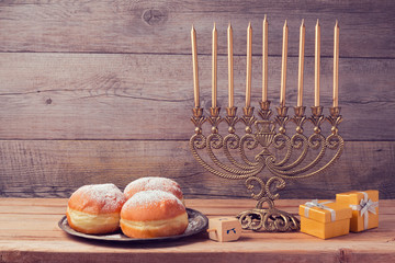 Jewish holiday hanukkah celebration with vintage menorah over wooden background © maglara