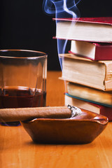 Zapalone cygaro, drink i stos książek © GieZetStudio