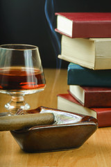 Drink w kieliszku, zapalone cygaro i książki © GieZetStudio