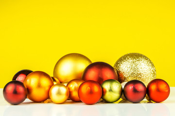multicolored christmas balls on yellow background