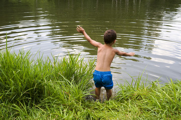 Child jumping into lake, pond or river