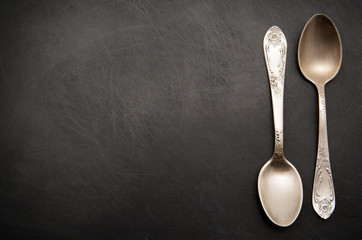 Vintage metal spoons on dark background