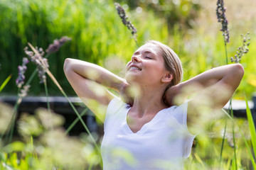 relaxation outside - relaxed young woman daydreaming,enjoying sun and vacation with green surrounding, summer daylight