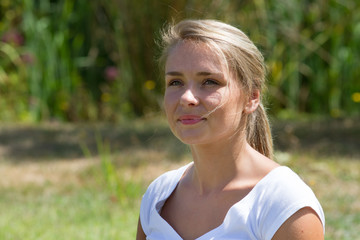 relaxation outdoors - natural young woman smiling,enjoying sun with green park background,summer daylight