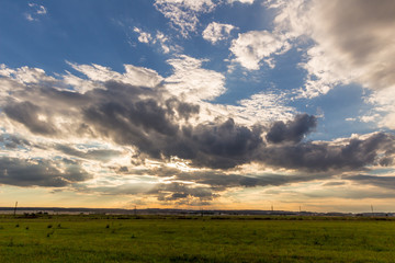 Obraz premium Dramatic sunset over green field 