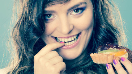 Smiling cute woman holds fruit cake in hand