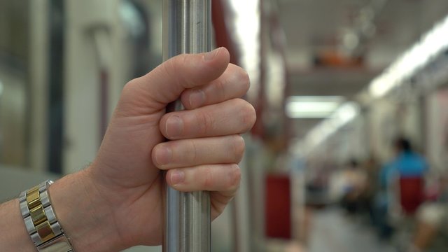 4K Man Holds Rail in Subway Car