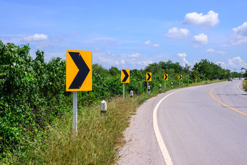 Curve road and right tuning sign with blue sky.