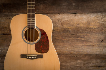 Obraz premium Top view of guitar on dark wood floor texture in darken tone
