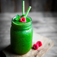 Fresh green smoothie on rustic wooden background