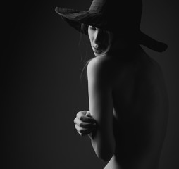Obrazy na Szkle  Topless kobieta w dużym eleganckim kapeluszu.