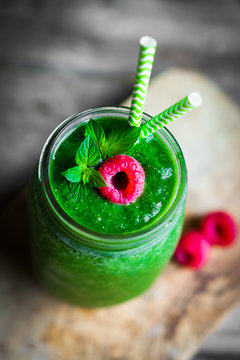 Fresh green smoothie on rustic wooden background