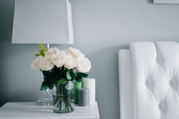 Fototapeta premium Bouquet of white pastel roses in white interior