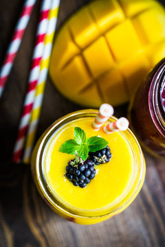 Colorful two layer smoothies with mango and berries on rustic wo