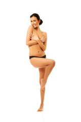 Laughing woman standing with bended knee