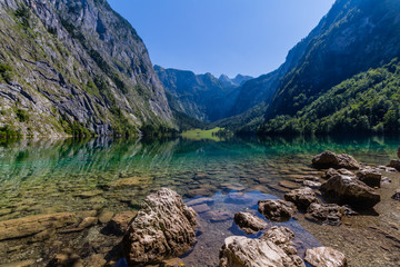 Beautiful landscape of alpine lake with crystal clear green water and mountains in background, Obersee, Germany