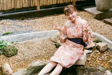 Asian woman wearing yukata in Asian garden