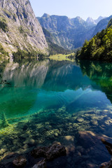 Fototapeta na wymiar Beautiful landscape of alpine lake with crystal clear green water and mountains in background, Obersee, Germany