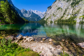 Obraz premium Beautiful landscape of alpine lake with crystal clear green water and mountains in background, Obersee, Germany