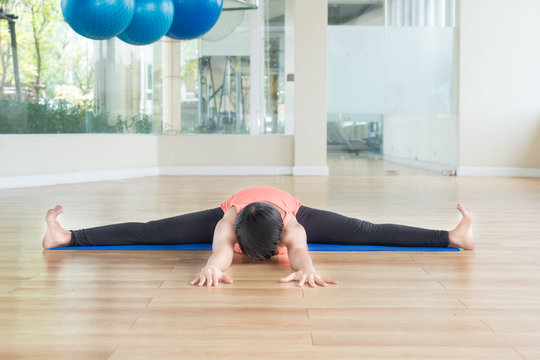 Asian woman make yoga Wide-angle seated forward bend pose in cla