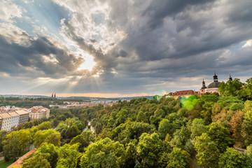 View of Prague taken from Nuselsky bridge on sunset captures typical local architecture from aerial perspective. Famous Vysehrad castle is behind it.