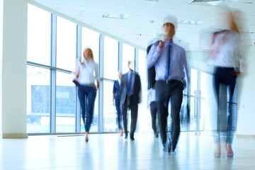 businesspeople walking in the corridor of an business center - Powered by Adobe