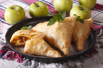 Delicious homemade cut turnover with apples and raisins close-up 
