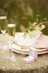 white wine in glass and diamond ring on table