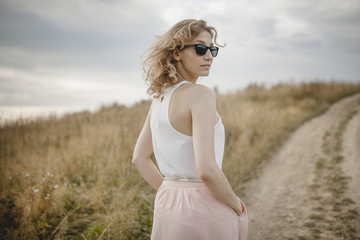 Fototapeta na wymiar beautiful young woman posing on a meadow. Summer fashion photo. Lifestyle