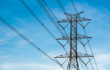High voltage transmission lines isolated on blue sky background