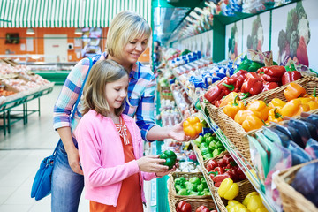 Mother and daughter chooses bell peppers