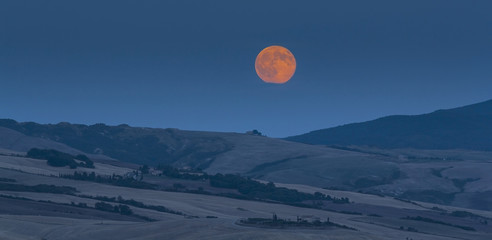 Tuscan landscape. Picturesque countryside villa under full moon