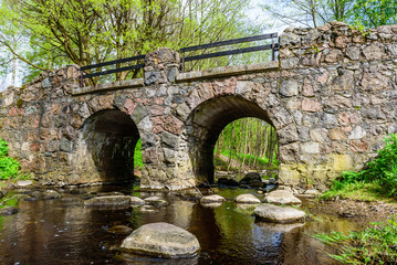 Stone arch bridge in a city Park, Oranienbaum (Lomonosov), St. Petersburg, Russia.