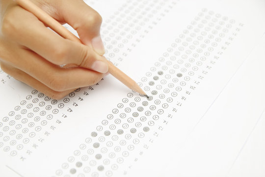 Standardized test form with answers bubbled in and a pencil, foc