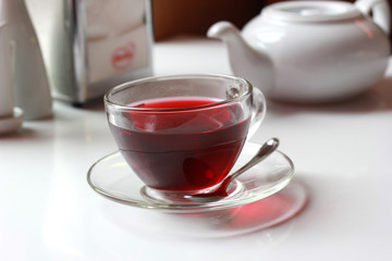 Transparent glass cup of red fruit tea on the table