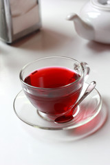 Transparent glass cup of red fruit tea on the table