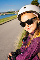 Fototapeta na wymiar Little girl wearing in roller skates protection outdoors